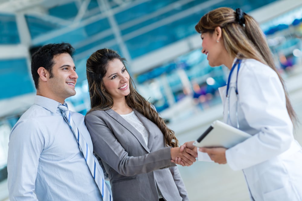 Doctor handshaking with a couple at the hospital Doctor handshaking with a couple at the hospital