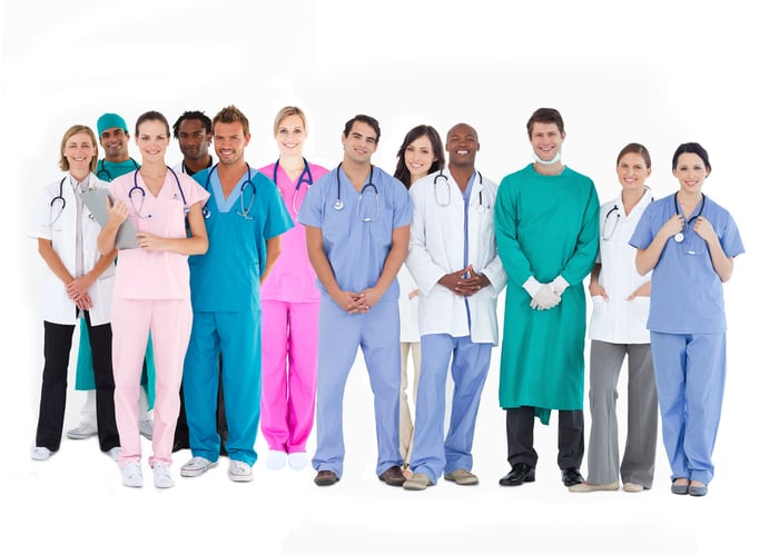 Smiling medical team of doctors nurses and surgeons on white background Smiling medical team of doctors nurses and surgeons on white background